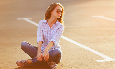 Wall Mural - Beautiful smiling young woman over summer sunny evening background