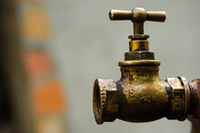 Old Brass Water Tap Isolated On A Light Background. Tap Valve. Old Copper Retro Faucet On A Rusty Pipe. Plumbing, Repair, Dismantling. Vintage Close-up. Outdoor Water Tap
