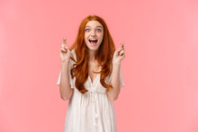 Lucky Good-looking Happy, Excited Redhead Caucasian Girl Seeing Her Dream Came True After Praying With Fingers Crossed, Looking Amazed And Surprised, Rejoice From Wish Fulfilled, Pink Background