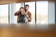 © Drazen - Young excited man covers wife's eyes while surprising her with their new home.