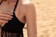 Sunburn on the shoulder and neck of a young woman at the beach. Female wearing a bikini showing her red tan lines and damaged skin from the sun due to lack of uv, sun screen protection