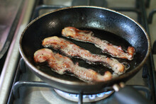 Closeup Shot Of Bacon Sizzling And Cooking In A Pan