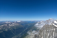 Aerial View From Aiguille Du Midi On European Alps And Chamonix In The Distance. Mountain Ranges Covered With Snow