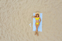 Woman Sunbathing On Beach Towel At Sandy Coast, Aerial View. Space For Text