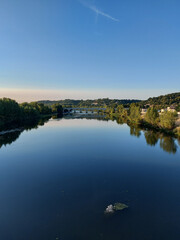 Canvas Print - Beautiful shot of blue river water surrounded by mountain landscapes and buildings