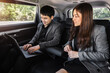 © geargodz - two business man and woman working with laptop computer while sitting in the back seat of car