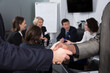 © JackF - Closeup of international businessmen handshake on blur meeting room background