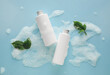 Bottles of cosmetic products and foam on color background
