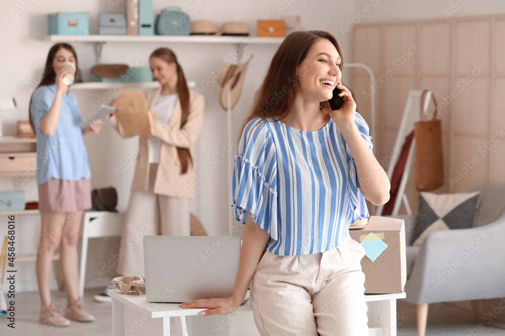Female business owner processing order in shop
