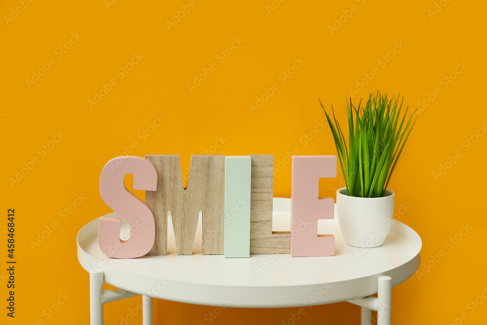 Stylish decor with houseplant on table near color wall