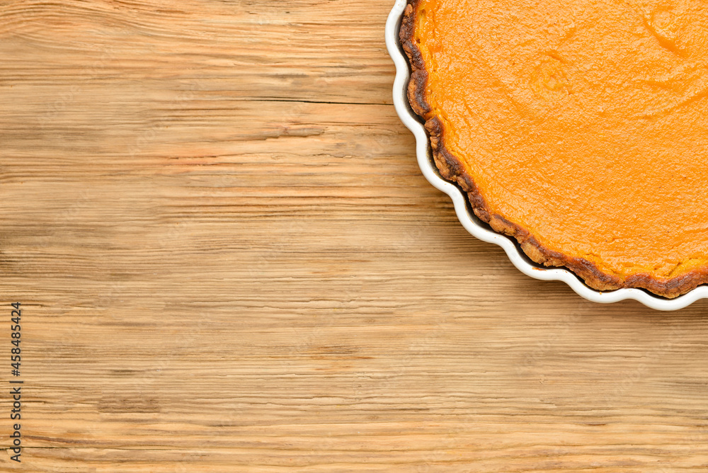 Baking dish with tasty pumpkin pie on wooden background, closeup