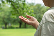 © Kana Design Image - Hand of the elderly or middle-aged woman taking medicine in nature. 自然の中で薬を持つ高齢なまたは中高年の女性の手