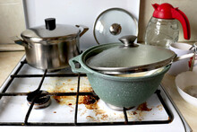 Dirty Kitchen. Dirty Gas Stove With Food Debris And Grease Splashes. Dirty Dishes