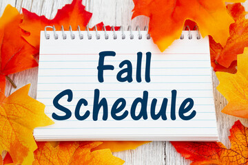 Wall Mural - Fall Schedule message on lined notepad on with fall leaves