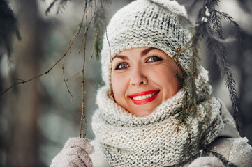 Portrait of a woman in gray clothes in a winter forest.Girl in the new year's snow-covered forest.