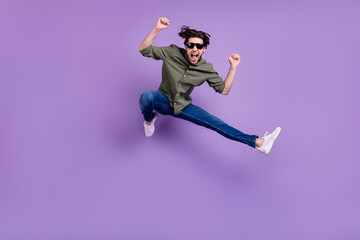 Poster - Full size photo of crazy cool happy young man jump up winner wear sunglass isolated on violet color background