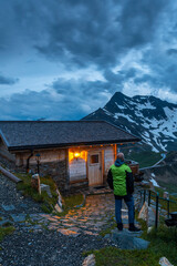 Poster - Adventure Man Looking at Mountain Peak From Wooden Chalet