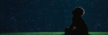 Child Sit On The Grass At Night And Look At The Christmas Night Sky