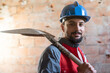 © FotoAndalucia - construction worker with shovel looks at camera with helmet smiling