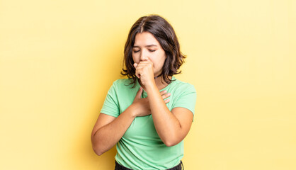 Wall Mural - young pretty girl feeling ill with a sore throat and flu symptoms, coughing with mouth covered