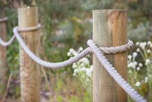 Fence Made Of Rope And Wooden Pole In Park