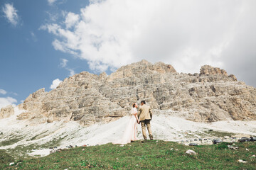 Wall Mural - Loving husband and woman on the background of the mountains. Loving couple emotionally spends time