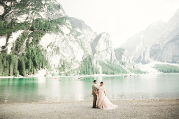 Wall Mural - Young couple near a beautiful lake in the mountains. Lovers love one another close and smile