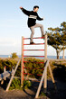 © javiemebravo - .young man juggling on top of a ladder
