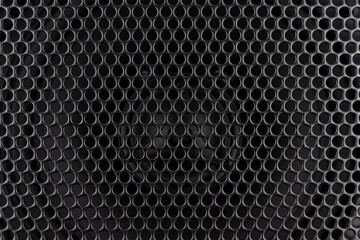 Stylish car audio acoustic round speaker with waffle grill protector cover closeup. Modern music black background texture