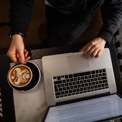 Wall Mural - Man businessman working at laptop and drinking coffee, top view