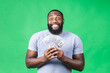 © denis_vermenko - Winner! Young rich happy african american black man in casual holding money dollar bills with surprise isolated over green wall background.
