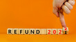 Planning 2022 refund new year symbol. Businessman turns wooden cubes and changes words 'refund 2021' to 'refund 2022'. Beautiful orange background, copy space. Business, 2022 refund new year concept.