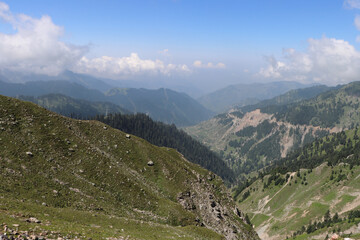 Canvas Print - Beautiful view of the chains of mountains covered in grass on a sunny