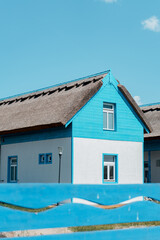 Wall Mural - Beautiful turquoise country house in the foreground of a wooden fence entrance