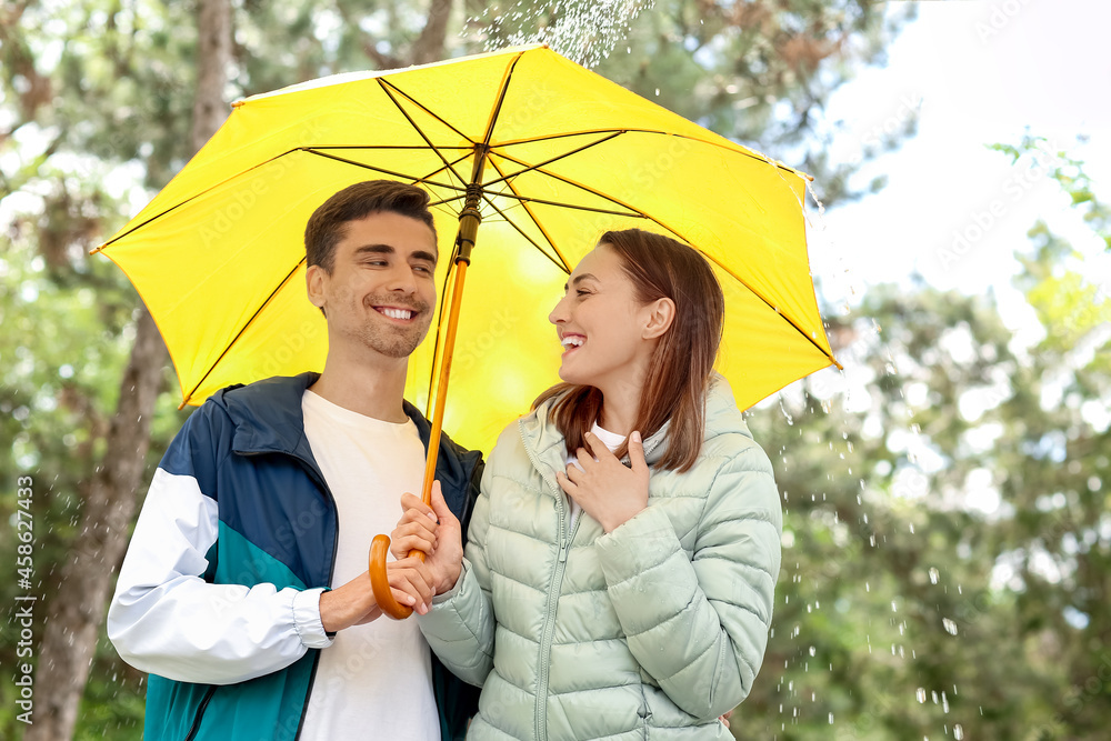 Young couple with umbrella in park