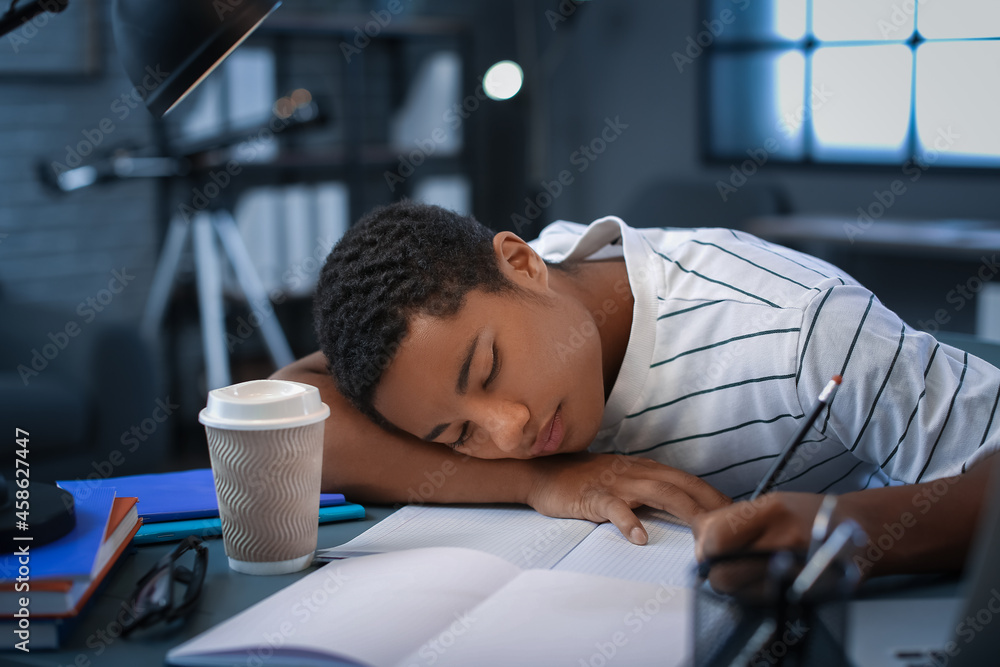Tired African-American student preparing for exam at home