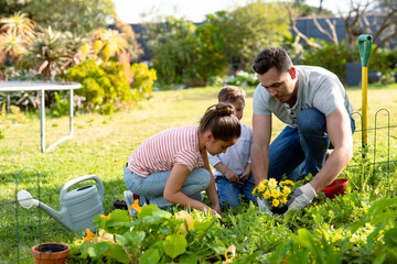 Happy caucasian father, daughter and son gardening together