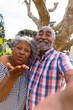 Happy african american senior couple taking selfie and sending kisses