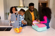 © wavebreak3 - Happy african american parents and children preparing backpacks for school
