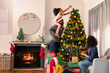 © wavebreak3 - Happy african american parents and daughter decorating christmas tree