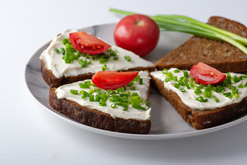 Wall Mural - Slices of bread with cottage cheese, onion and tomatoes on plate on white background