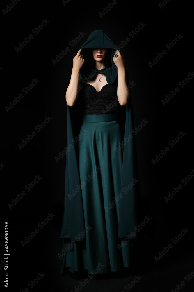 Beautiful woman dressed as witch for Halloween party on dark background