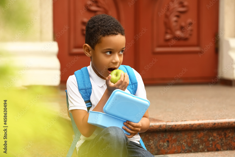 Cute little boy having school lunch outdoors