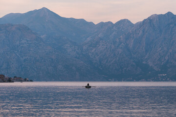 Wall Mural - Kotor / Montenegro - September 15 2021: View of a boat and the Kotor Bay at sunset, touristic famous destination in Montenegro, Europe