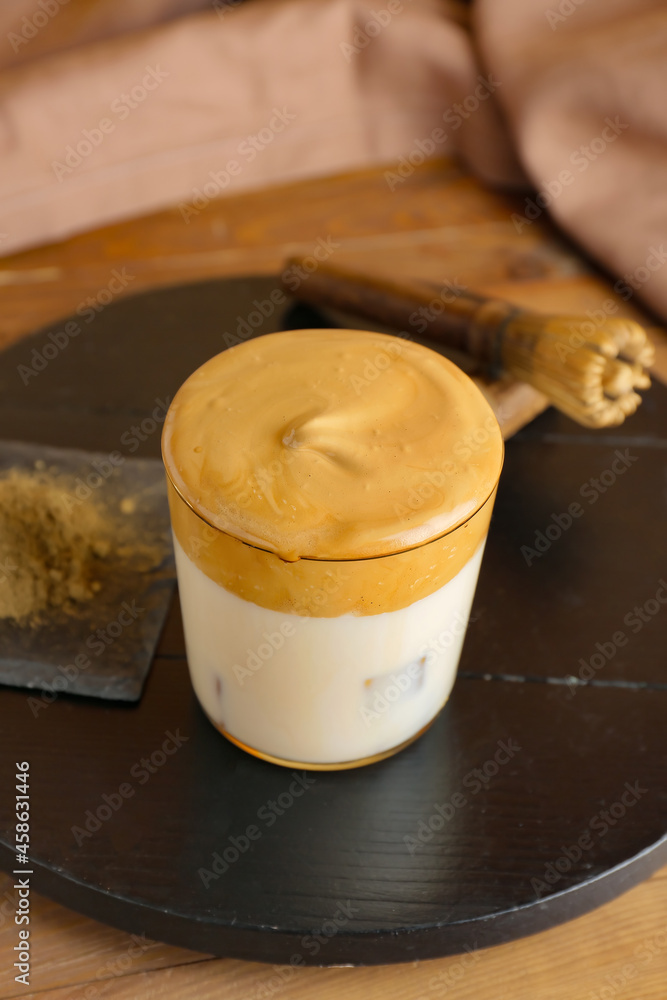 Glass of tasty dalgona hojicha latte on table
