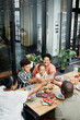 © Seventyfour - Vertical portrait of big African-American family clinking glasses while enjoying dinner together outdoors and celebrating, copy space