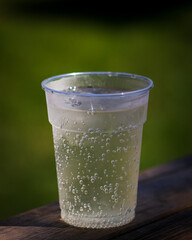 Wall Mural - Vertical shot of a cup of clean water on a wooden surface