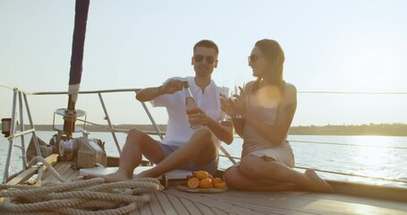 Sticker - Happy young couple drinking champagne on yacht 