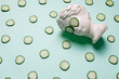 Fresh cucumber slices pattern and ancient bust with a cucumber slice mask on eyes on green background. Creative beauty concept. Spa beauty treatments at home, body care concept, organic cosmetics.