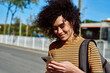 © pablocalvog - Smiling young woman reading a text by the roadside